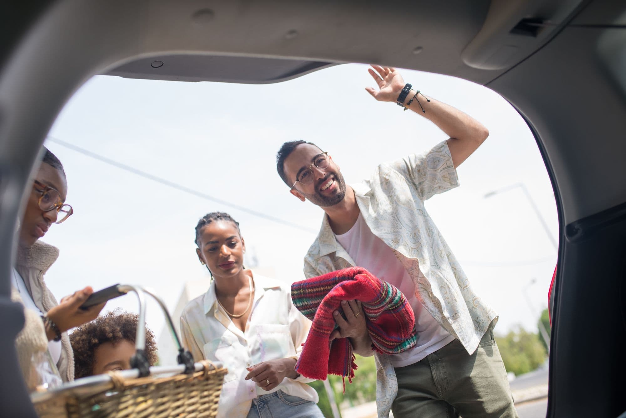 A family loading up their vehicle on a sunny day
