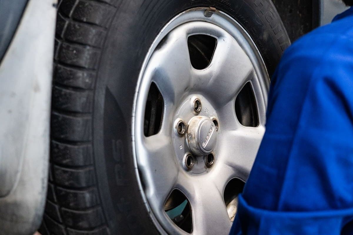 A technician inspecting a wheel and tire